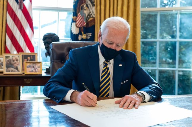 President Joe Biden signs the commission